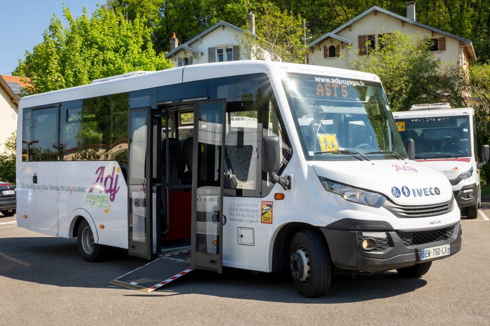 Minibus Iveco blanc ADJ Voyages avec sa rampe d’accès PMR déployée